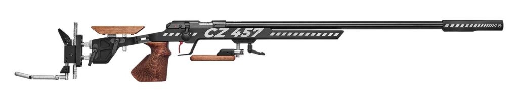 This image shows a detailed, high-resolution studio shot of a CZ 457 Target rifle against a plain white background.

The rifle dominates the composition, oriented horizontally with its muzzle pointing left. It has a sleek, modern design with a black barrel and receiver. White stripes and the word "TARGET" are prominently displayed on the side. The trigger is red, offering a pop of color. The stock is made of wood, adding a touch of classic elegance to the weapon. The rifle is also equipped with adjustable sights and other accessories, suggesting it is designed for precision shooting. The lighting is even and diffused, highlighting the details of the rifle without harsh shadows. The overall atmosphere is professional and technical, emphasizing the rifle's precision and quality.