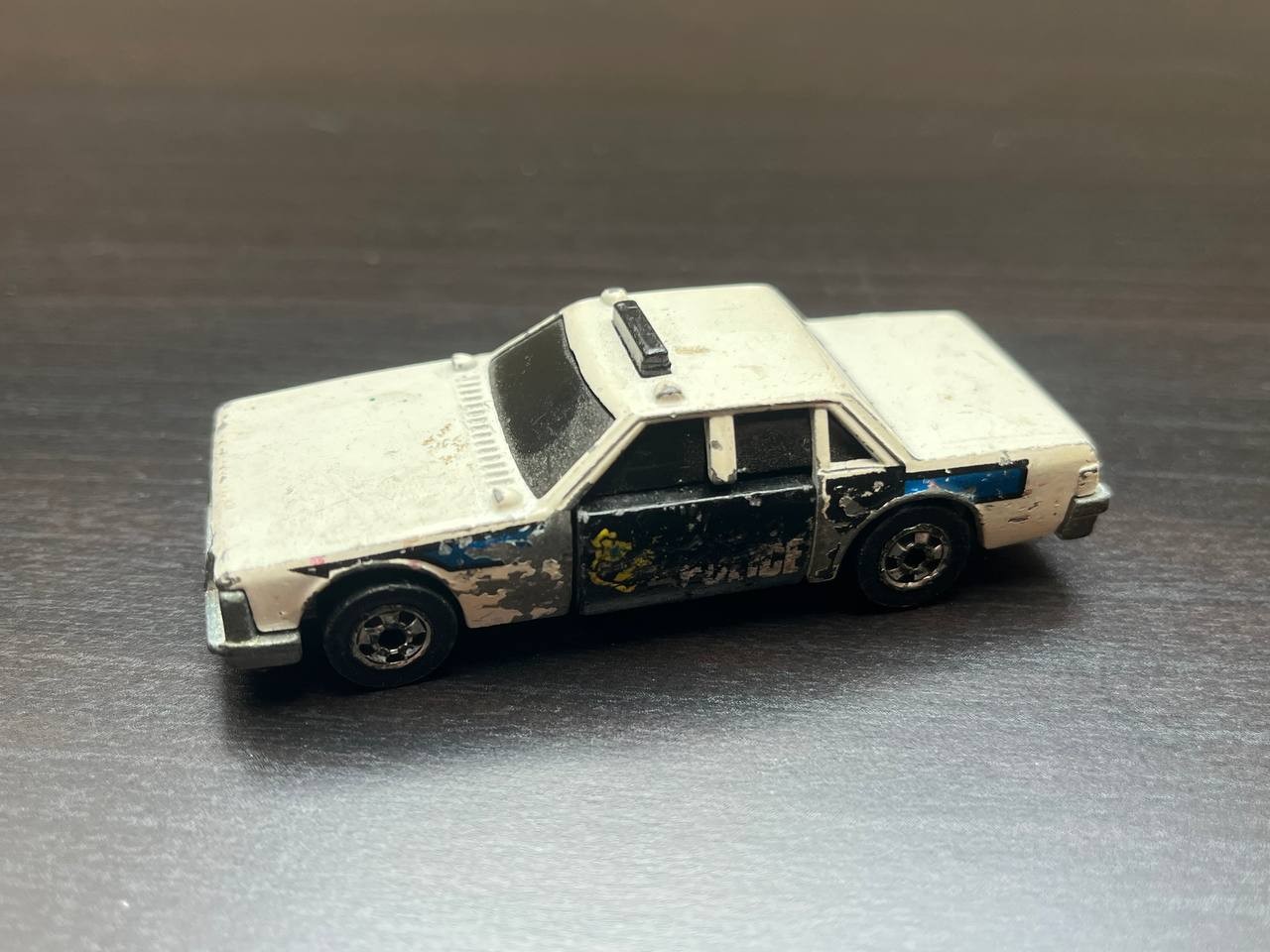 A police car with a door that is hinged horizontally, so that when there is an impact, the door flips over and then looks like it is damaged.